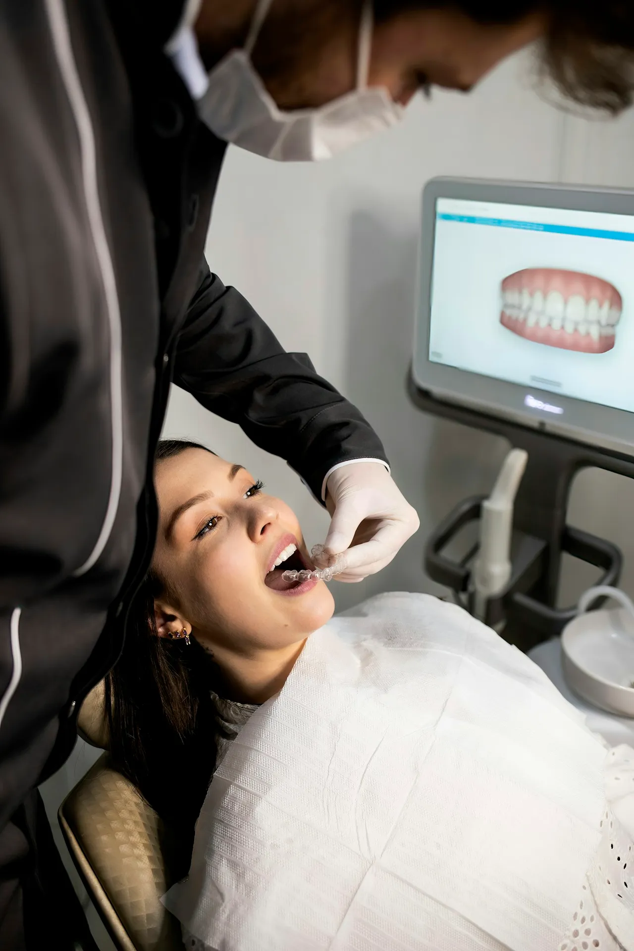 Pacientă relaxată pe scaunul stomatologic, lângă un scaner 3D