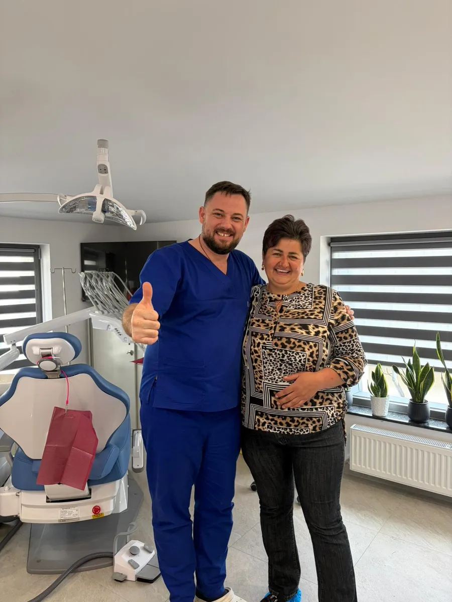 Pacienta multumita alaturi de medicul stomatolog, in cabinetul din Falticeni